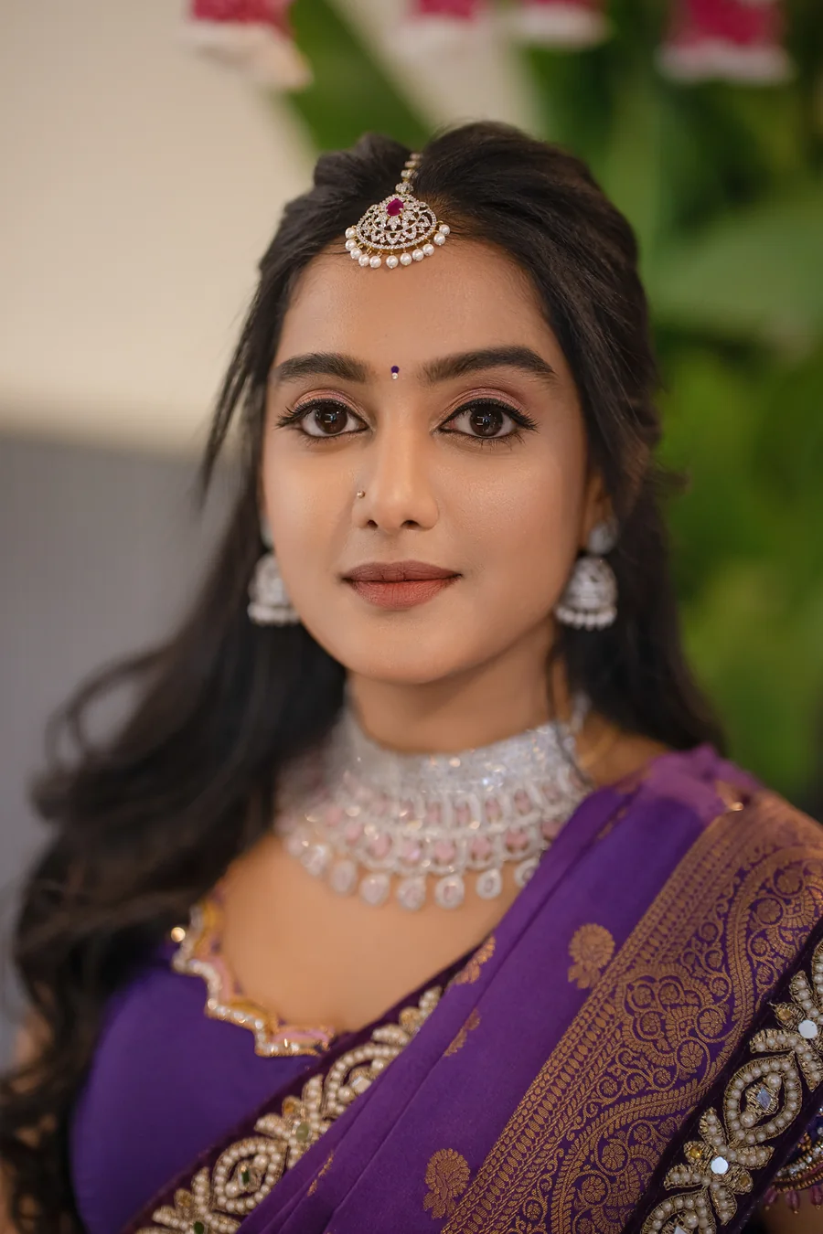 Harini Veena in a purple silk saree with a diamond choker and maang tikka