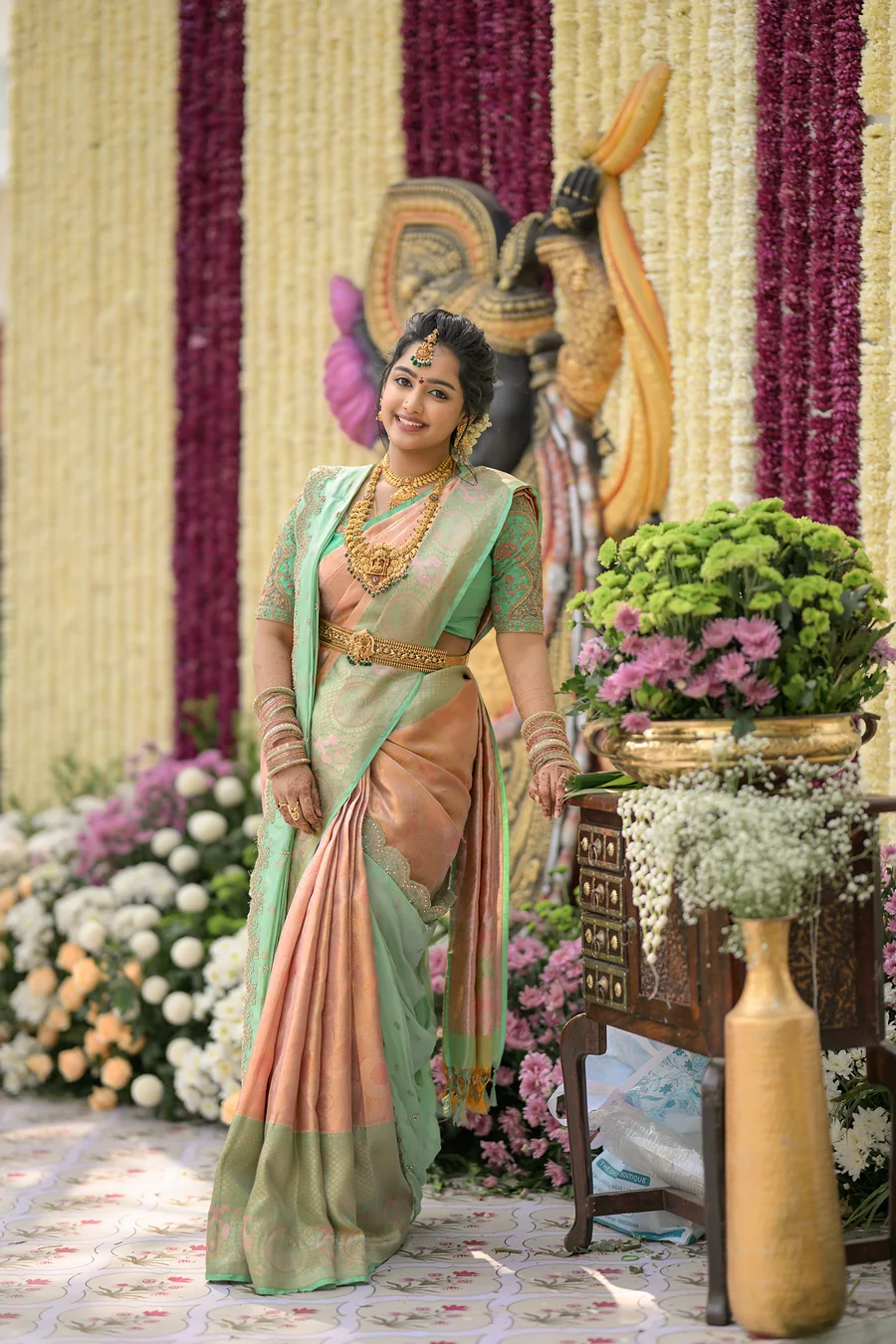 Full-length view of a peach silk saree with a mint border and gold jewellery