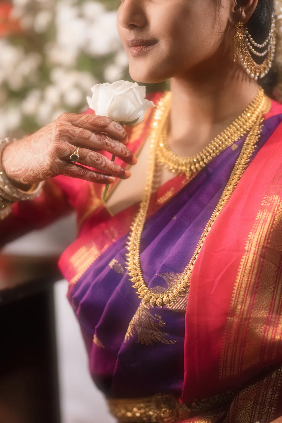 Detail of a long gold necklace and jhumka earrings